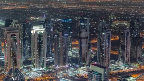 Jumeirah Lakes Towers distrito con muchos rascacielos a lo largo de Sheikh Zayed Road timelapse noche aérea. — Vídeo de stock