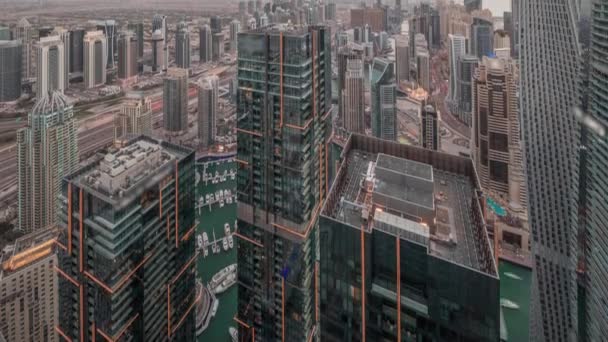 Dubai Marina en JLT district met verkeer op de snelweg tussen wolkenkrabbers antenne dag tot nacht timelapse. — Stockvideo