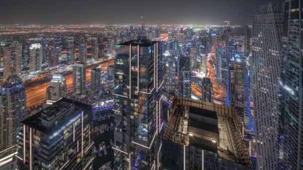 Panorama visar Dubai Marina och JLT distrikt med trafik på motorvägen mellan skyskrapor antenn natt timelapse. — Stockvideo