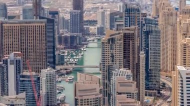 Dubai Marina 'nın Skyline görüntüsü tüm gün boyunca kıyı şeridi boyunca gökdelenlerle çevrili yapay bir kanal gösteriyor. Dubai, BAE