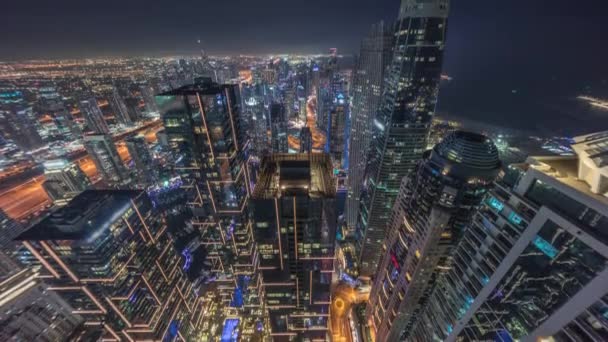 Vue panoramique de la marina de Dubaï montrant le canal entouré de gratte-ciel le long du littoral la nuit timelapse. DUBAI, EAU — Video