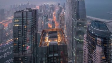 Dubai Marina 'nın gökdelenlerle çevrili gökdelenleri gece gündüz gösteren gökyüzü panoramik görüntüsü. Dubai, BAE
