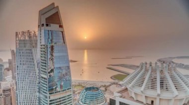 JBR ve Dubai Marina gökdelenlerinin gün batımı manzarası ve yukarıdan gelen lüks binalar.