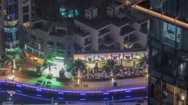 Dubai Marina 'daki hava manzarası palmiyeler ve yatlar ile aydınlatılmış gezinti alanı..