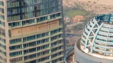 Modern gökdelen zaman çizelgesinde pencereleri temizleyen adamlar. Turistlerle dolu JBR plajı