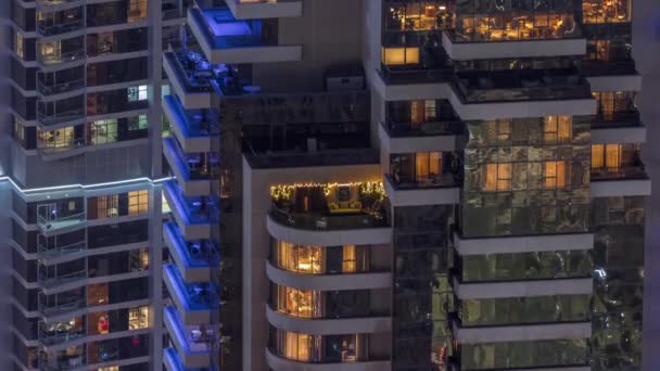Luz en ventanas de torres modernas. Exterior del edificio de apartamentos por la noche con ventanas brillantes timelapse. — Vídeo de stock
