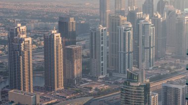 Şeyh Zayed Yolu yakınlarındaki JLT gökdelenleri. Arkasında konut binaları ve villalar var. Gün batımında sisli hava