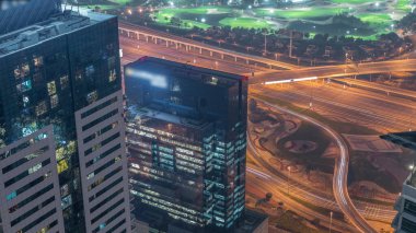 Golf sahası ile Dubai Marina arasındaki kavşak Sheikh Zayed Yolu ile kesişiyor. Ofis kulelerindeki aydınlık pencerelerin yakınındaki araba trafiği