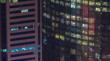 Gecenin ilerleyen saatlerinde gökdelenlerin camlarında parlayan ve yanıp sönen iç ışıkları olan pencereler. Havadan üst görünüm