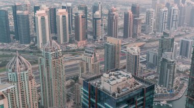 Şeyh Zayed Yolu yakınlarındaki JLT ve Dubai marina gökdelenleri. Gün gece hava geçiş zamanı. Aydınlatılmış konut binaları ve karayolu trafiği