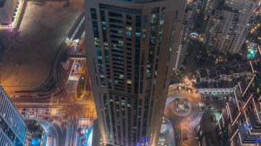 Gökdelenler arasındaki yol kesişimlerine yukarıdan bak. Büyük bir zaman diliminde. BAE 'nin Dubai Marina bölgesinde arabalar ve lüks kuleleri olan şehir manzarası