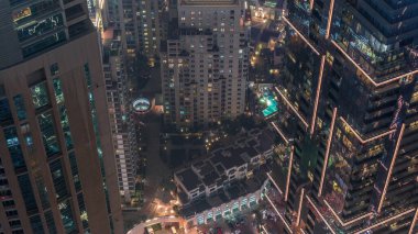Yukarıdan Dubai gökdelenleri perspektif zaman çizelgesine bakar. Dubai Marina hava manzaralı. Cam yüzeyde gece aydınlatması