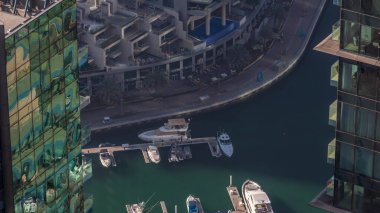 Dubai Marina Rıhtımı, gölgeli hava zaman ayarlı, Dubai, BAE. Gökdelenler arasında birçok restoran, yüzen yat ve tekne var.