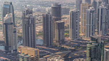 Şeyh Zayed Yolu yakınlarındaki JLT gökdelenleri. Arkasında göller olan konut binaları ve villalar. Uzun gölgeler hızlı hareket eder