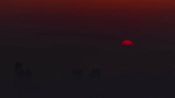 朝のドバイのスカイラインを見下ろす日の出 ドバイのマリーナからの空中トップビューのタイムラプス 高層ビルの周りをオレンジ色の空の大きな太陽が霧の上に昇る アラブ首長国連邦 — ストック写真