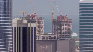 Vinçler yeni gökdelen zaman çizelgesinin modern soyutlama sahasında çalışıyor. Hızlı kentsel gelişim etkinliği kutsa ve inşa et