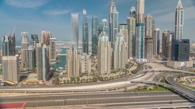 Dubai Marina 'nın gölgeli gökdelenleri Sheikh Zayed Yolu' nda gün boyunca en yüksek yerleşim yerlerinin bulunduğu kavşağa doğru hızla ilerliyor. JLT bölgesinden hava üst görünümü