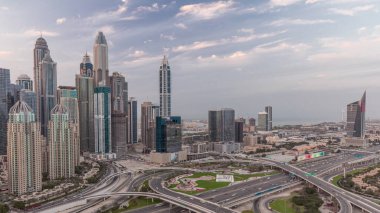 Dubai Marina Panoraması ve Medya Şehri kavşağı kavşağı spagetti kavşağı gün batımından sonra günden geceye geçiş zamanı. Arka planda en uzun gökdelenler aydınlatılıyor. JLT bölgesinden hava üst görünümü.