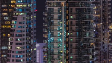 Gecenin ilerleyen saatlerinde gökdelenlerin dış tarafındaki pencereler zaman ayarında parıldıyor ve yanıp sönüyor. Havadan üst görünüm
