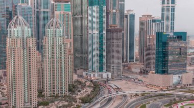 Dubai Marina 'nın gökdelenleri gün batımından gece saatlerine kadar aydınlatılmış en yüksek konut binaları. Otoyol kavşağı olan JLT bölgesinin hava üst görüntüsü