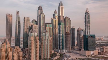 Dubai Marina 'nın en yüksek konutlu gökdelenleri ve uzun gölgeli sabah saatleri. Güneş doğarken JLT bölgesinin hava üst görüntüsü
