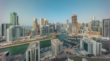 Dubai Marina 'da limana park etmiş çok sayıda tekne ve yat ve kanalın etrafında gökdelenler var..
