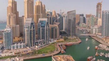 Dubai Marina 'da limana park etmiş çok sayıda tekne ve yat ve kanalın etrafında gökdelenler var..