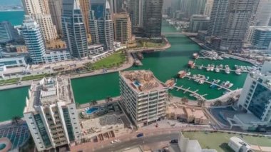 Dubai Marina 'da limana park etmiş çok sayıda tekne ve yat ve kanalın etrafında gökdelenler var..