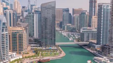 Dubai Marina 'da limana park etmiş çok sayıda tekne ve yat ve kanalın etrafında gökdelenler var..