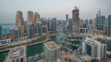 Dubai Marina 'da limana park etmiş birkaç tekne ve yatları ve kanalın etrafındaki gökdelenleri..