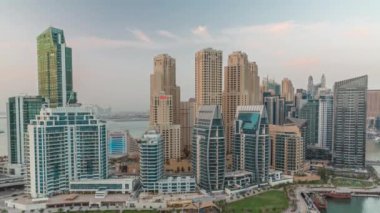 Dubai Marina 'da limana park etmiş birkaç tekne ve yatları ve kanalın etrafındaki gökdelenleri..