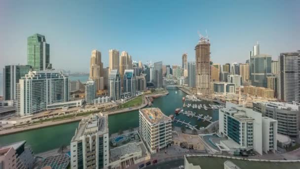 Dubai Marina with several boat and yachts parked in harbor and skyscrapers around canal aerial timelapse. — Stock Video