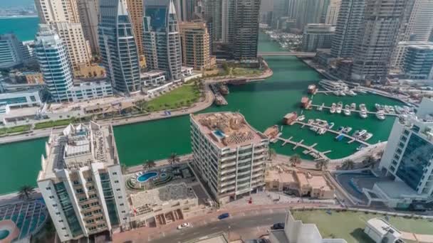 Dubai Marina több hajó és jachtok parkoló kikötőben és felhőkarcolók körül csatorna légi időelapszus. — Stock videók