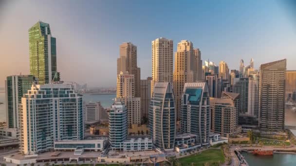 Dubai Marina with several boat and yachts parked in harbor and skyscrapers around canal aerial timelapse. — Stock Video
