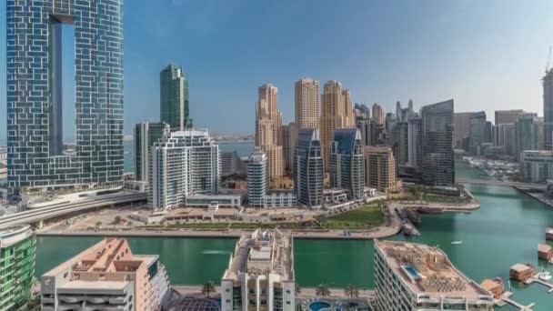 Dubai Marina con varios barcos y yates estacionados en el puerto y rascacielos alrededor del canal timelapse aéreo. — Vídeo de stock