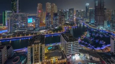 Dubai Marina 'da limana park etmiş birkaç tekne ve yatları ve kanalın etrafında gökdelenleri var..