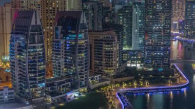 Dubai Marina 'da limana park etmiş birkaç tekne ve yatları ve kanalın etrafında gökdelenleri var..