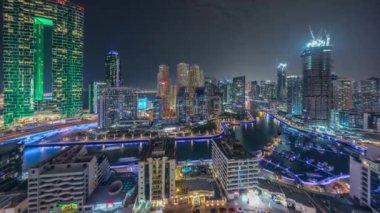 Dubai Marina 'da limana park etmiş birkaç tekne ve yatları ve kanalın etrafında gökdelenleri var..