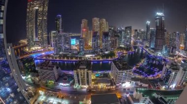 Dubai Marina Panoraması 'nda limana park etmiş çok sayıda tekne ve yat ve kanalın etrafında gökdelenler var..