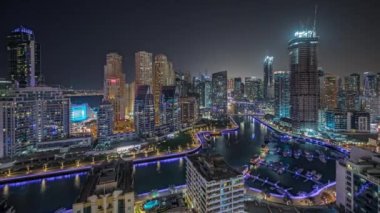 Panorama Dubai Marina 'yı birkaç tekne ve yatla gösteriyor. Limanda park halinde ve gökdelenler Kanal hava gece zaman çizelgesi etrafında..