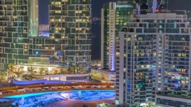 Dubai Marina 'daki modern gökdelenler, birçok aydınlatmalı pencereye yakın çekim gece zaman çizelgesi.