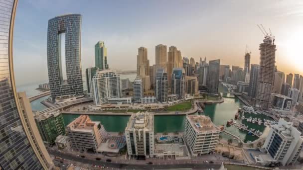 Dubai Marina s několika čluny a jachty zaparkované v přístavu a mrakodrapy kolem kanálu letecké ranní timelapse. — Stock video
