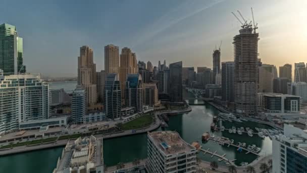 Panorama ukazuje Dubai Marina s několika čluny a jachtami zaparkované v přístavu a mrakodrapy kolem průplavu letecké ranní timelapse. — Stock video
