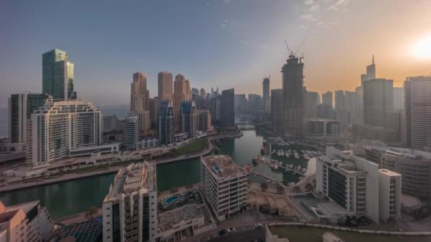 Dubai Marina több hajó és jachtok parkolt kikötőben és felhőkarcolók körül csatorna antenna egész nap időintervallum. — Stock videók