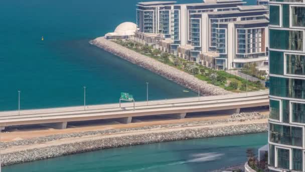 Promenade en Dubai stadsgezicht gezien vanaf Dubai jachthaven timelapse. Luchtfoto naar JBR district en Bluewaters Island achter — Stockvideo