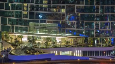 Gece vakti Dubai marinasından görülen gezinti güvertesi ve palmiye manzarası. JBR bölgesine hava görüntüsü