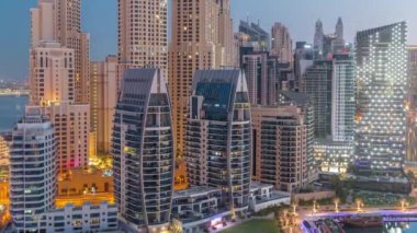 Dubai Marina gökdelenleri ve lüks binaları olan JBR bölgesi ve gece gündüz havadan dinlenme yerleri.