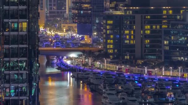 Sok jachtok és hajók parkolnak a kikötő légi éjszakai időbeosztás Dubai Marina — Stock videók