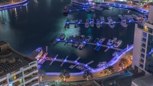 多くのヨットやボートは、ドバイマリーナの港の空中夜のタイムラプスに駐車されています — ストック動画