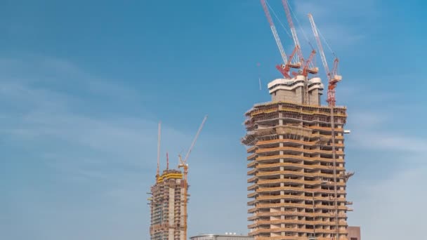Budowa wieżowców. Strona z żurawiami przeciwko błękitnemu niebu — Wideo stockowe